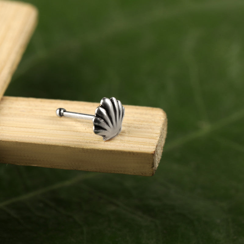 Close-up of 925 Sterling Silver Seashell Nose Pin placed on dark fabric surface
