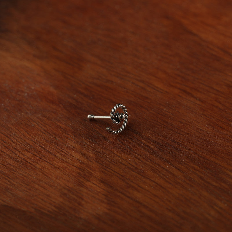 Close-up of 925 Sterling Silver Spiral Nose Pin placed on dark fabric surface