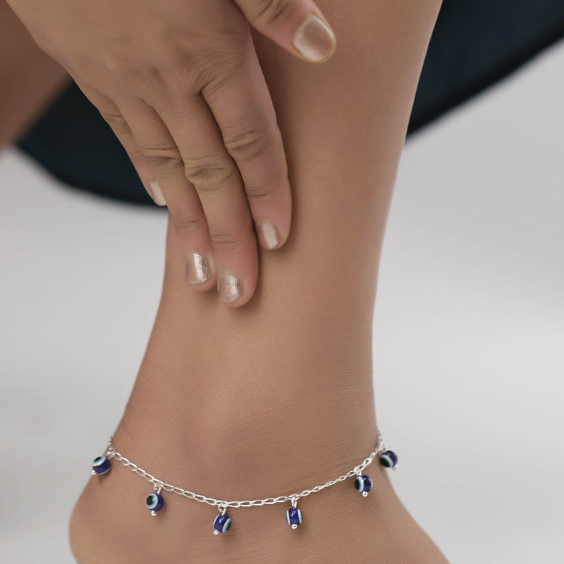 Woman styled with silver evil eye anklet, elegant accessory for Navratri wear and festive outfits.