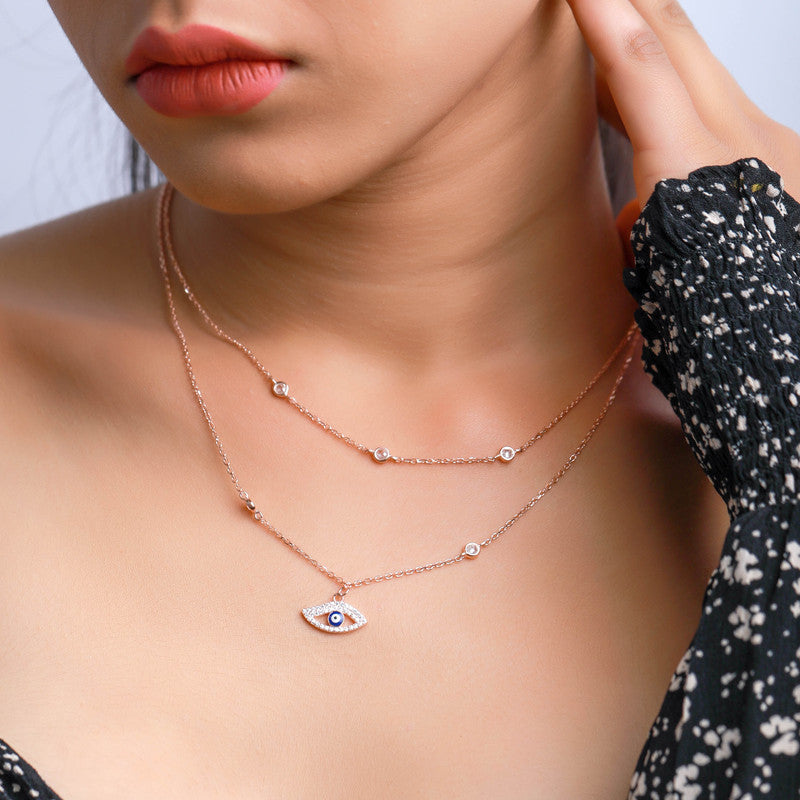 Woman wearing a layered rose gold evil eye silver necklace, adding charm and grace to her festive celebration look.