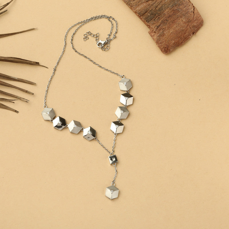 Close-up of pyramid charm pendant on silver chain — modern geometric design necklace.
