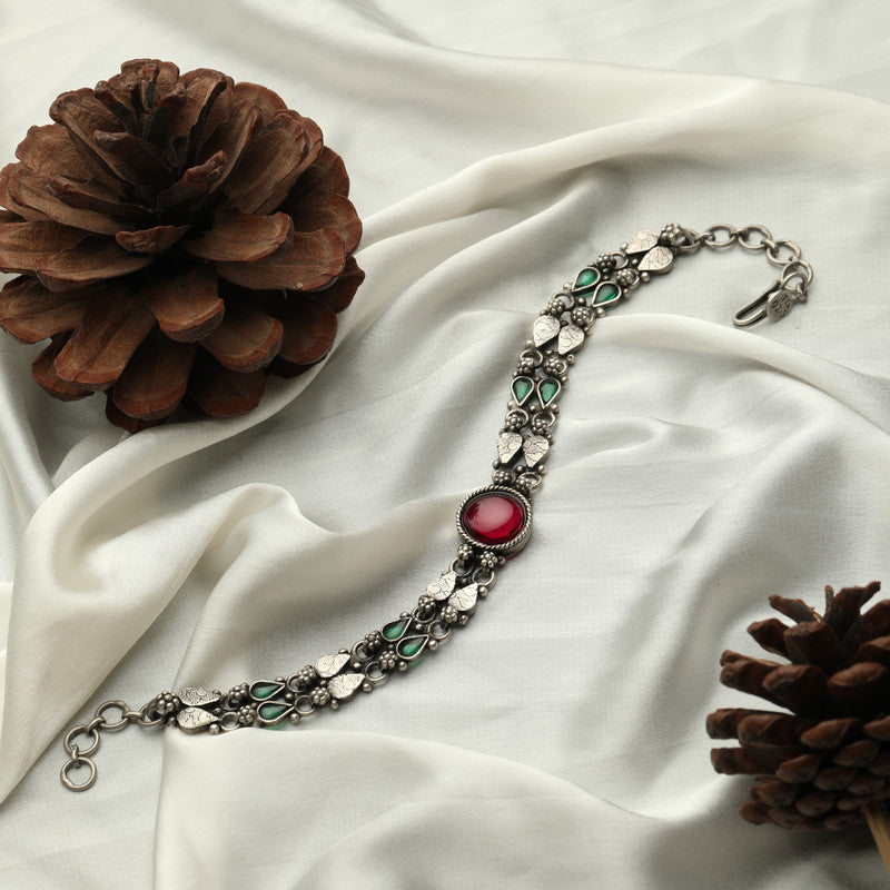 Antique silver layered chain bracelet displayed on fabric surface.