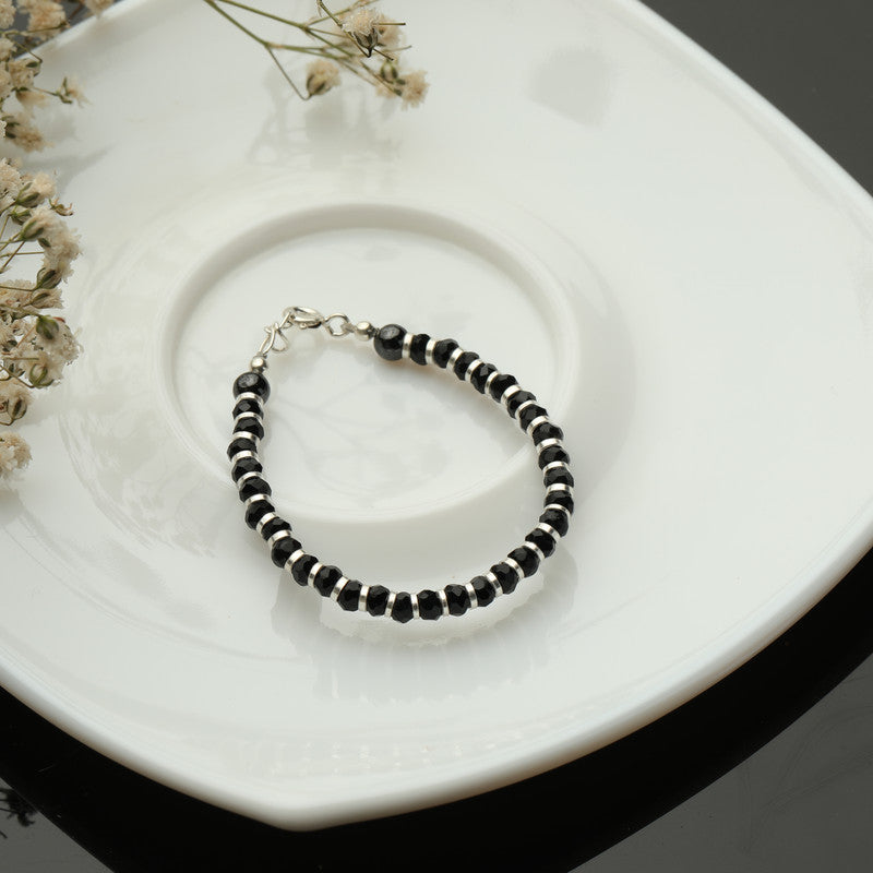 Kids Silver Charm Nazariya Bracelet with Silver Charm styled on fabric background