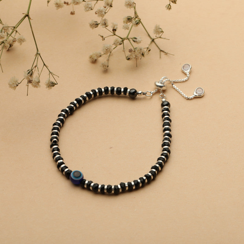 Kids Silver Evil Eye Nazariya Bracelet with Evil Eye Charm styled on fabric background
