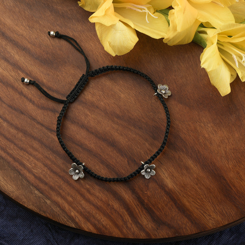 Shining silver evil eye anklet with floral charm, radiant piece for Karwa Chauth and Diwali wear.