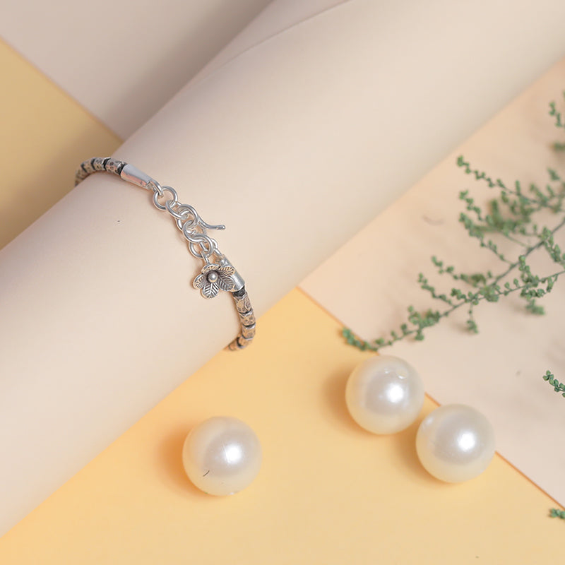 Stylish lucky charm silver bracelet placed Prop Image