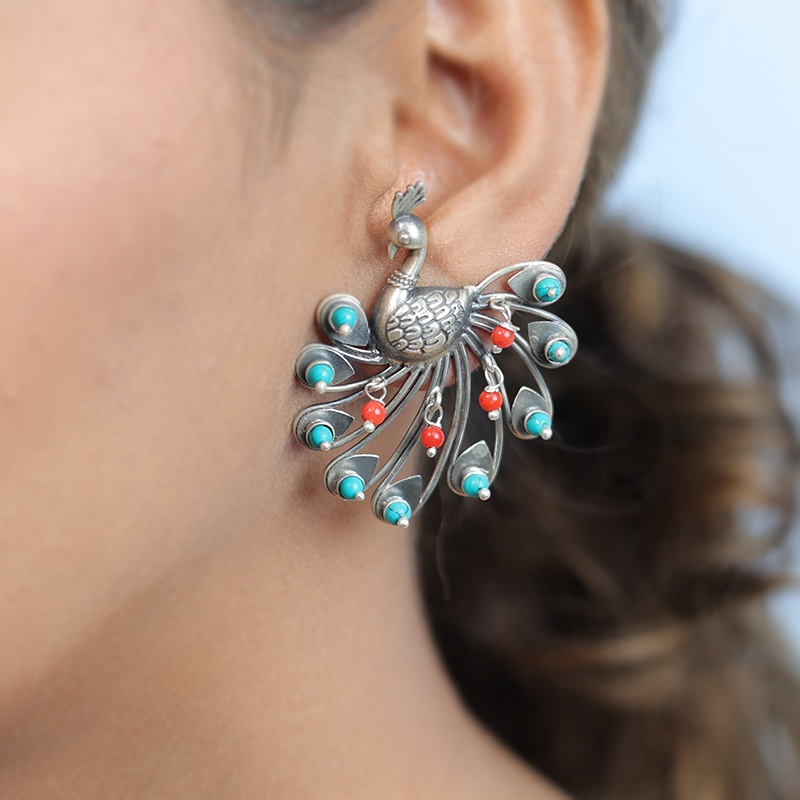 Oxidized silver dancing peacock earrings styled on model – graceful ethnic jewelry for weddings, parties, and festive functions