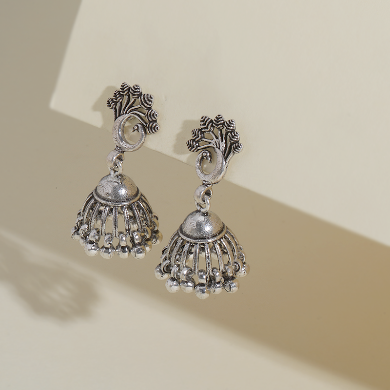 Oxidized silver peacock feather jhumka earrings on model – elegant festive accessory for weddings, Karwa Chauth, and cultural functions