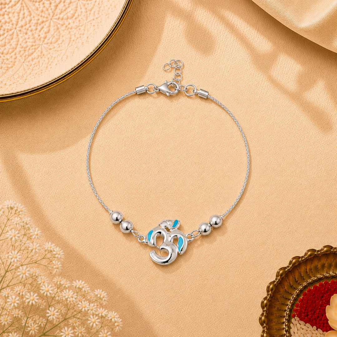 Silver Kartik Om Bracelet Rakhi for Kids placed with festive decor – premium 925 silver kids Raksha Bandhan gift by Silviya.