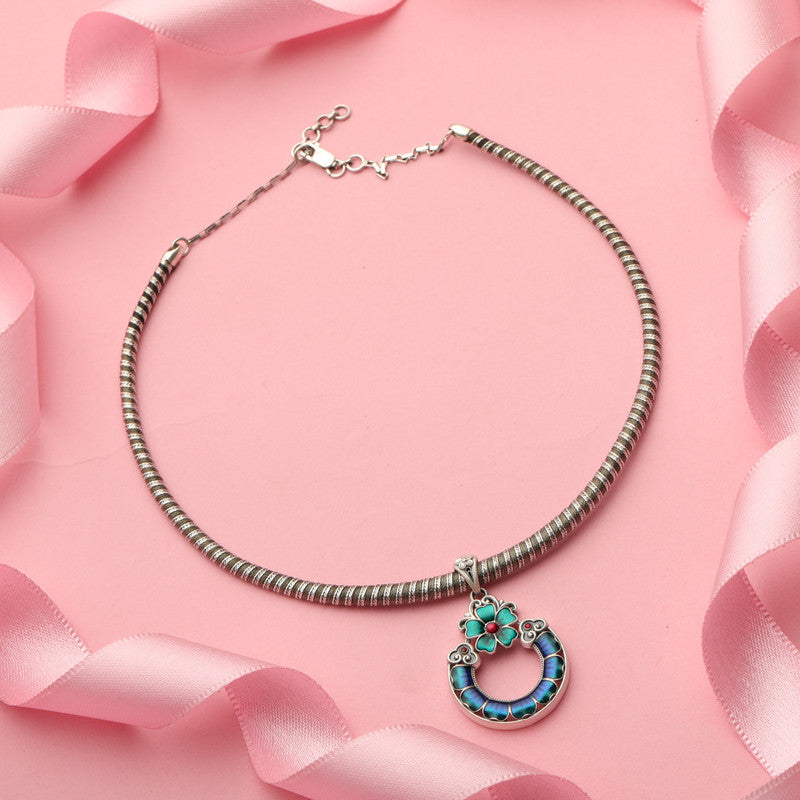 Close-up of 925 Silver Hollow Flower Pendant Necklace placed on dark fabric surface