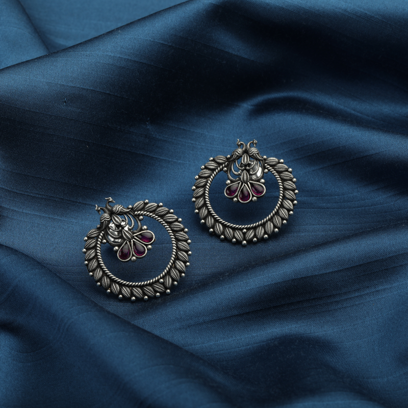 925 Silver Peacock Earrings placed on blue fabric – close-up jewelry shot