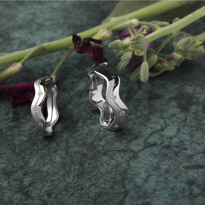 925 silver wavy couple bands displayed with props – romantic silver accessory set