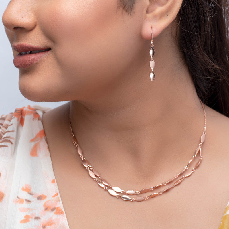 Woman wearing a twisted rose gold silver necklace, adding festive shine to her look.