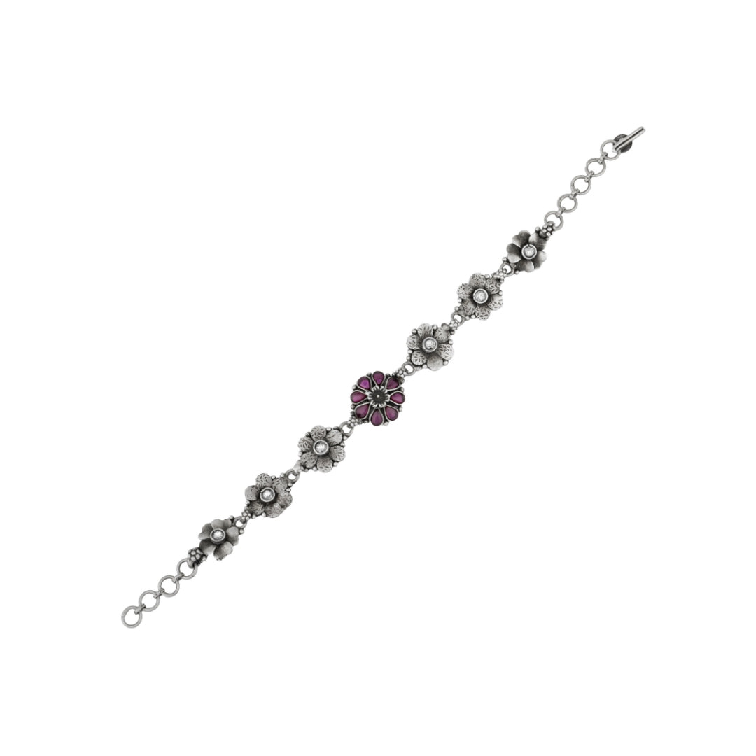 Close-up of antique silver bracelet with pink flower charm.