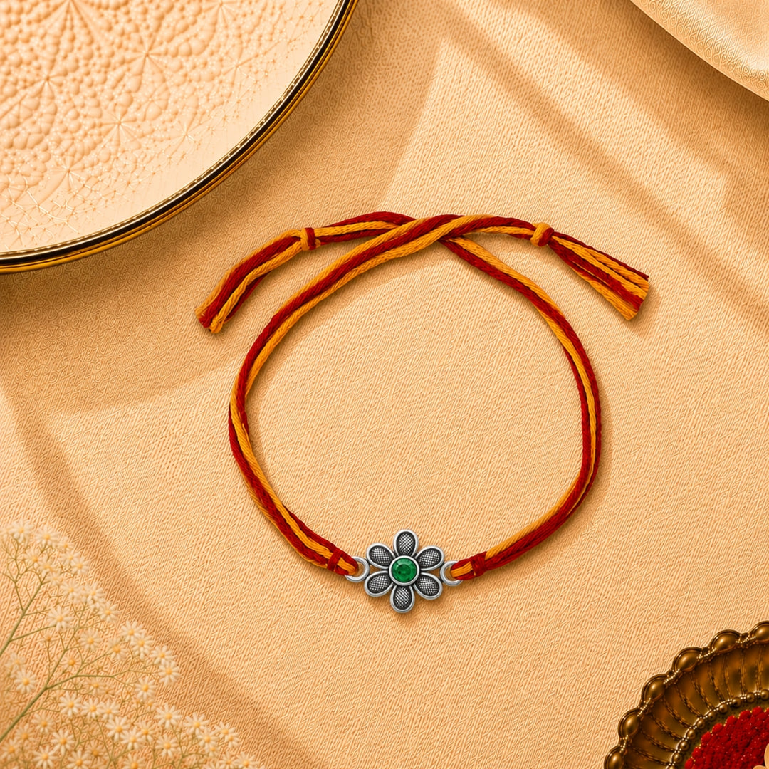 Oxidized Silver Flower Rakhi placed with roli chawal and festive decor – premium floral Raksha Bandhan gift by Silviya.