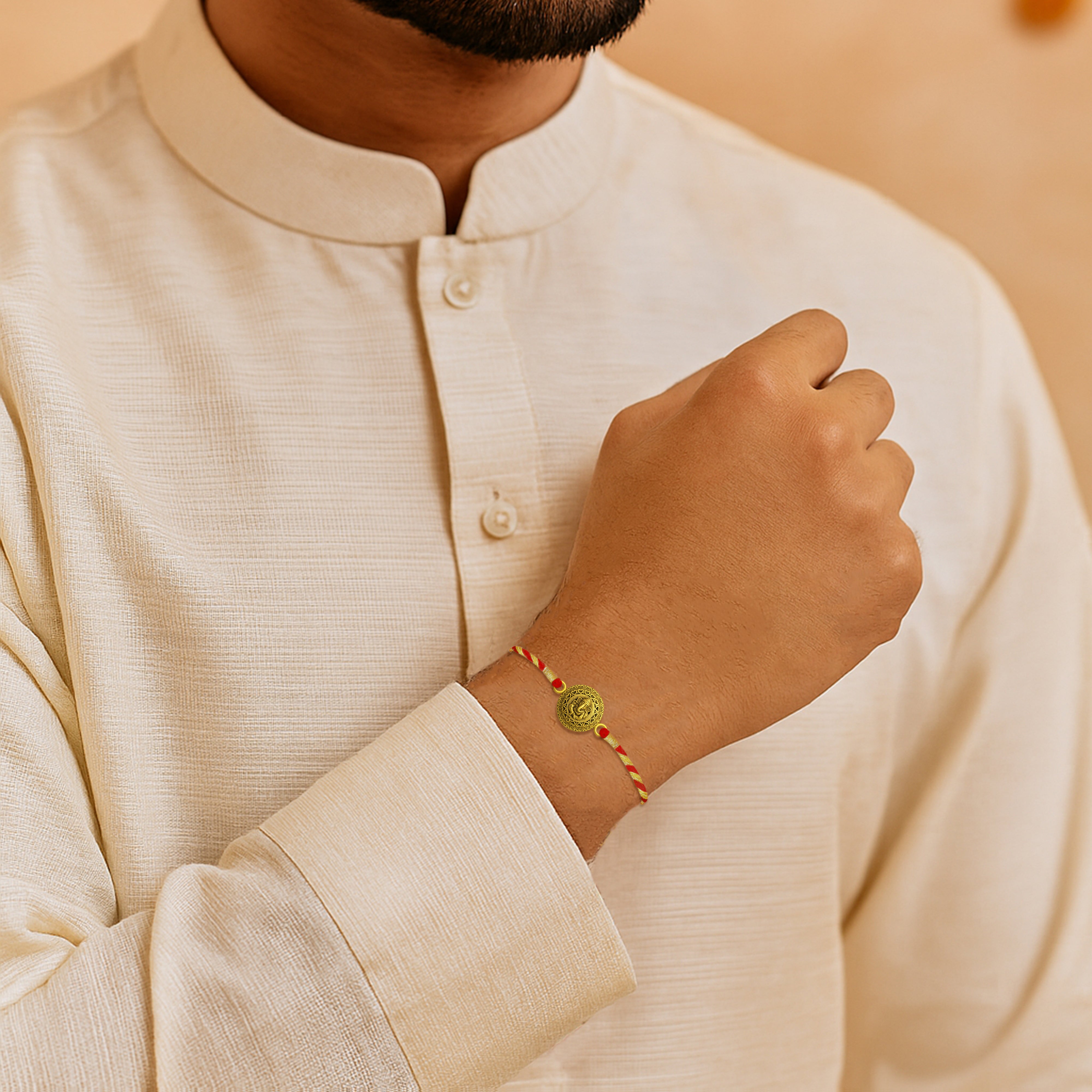 Person wearing a beige kurta with a close-up of a wrist wearing a rakhi.