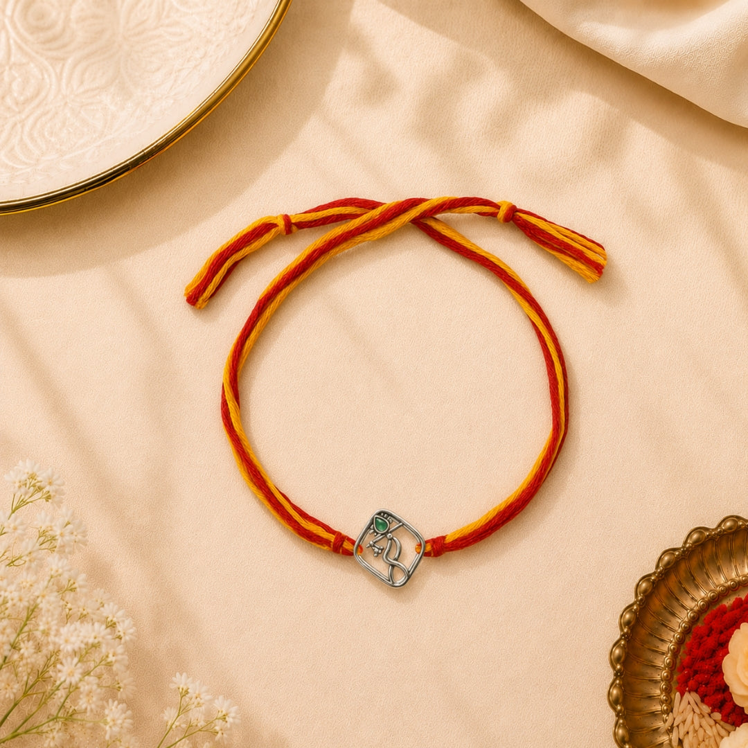Silver Krishna Bansuri Rakhi placed with roli chawal and festive decor – premium 925 silver Raksha Bandhan gift by Silviya.