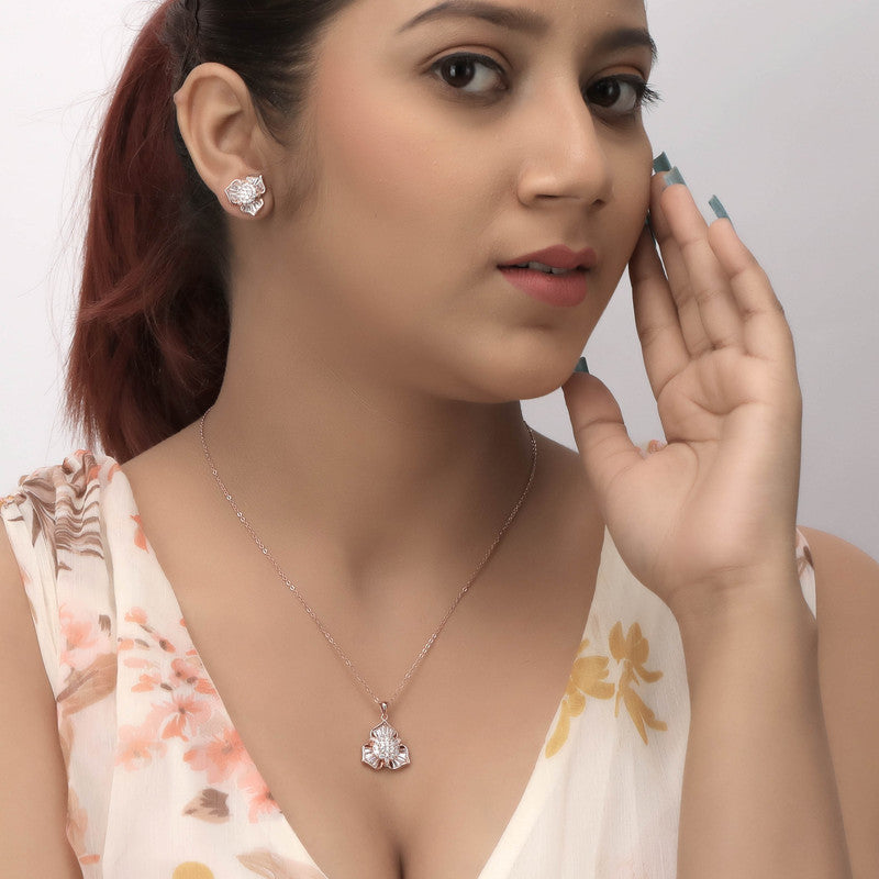A woman showcasing a delicate floret pendant set in silver, enhancing her festive outfit with graceful detail.